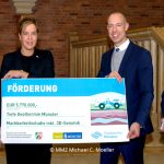 Mona Neubaur mit der Förderung für die Tiefe Geothermie in Münster in der Hand.